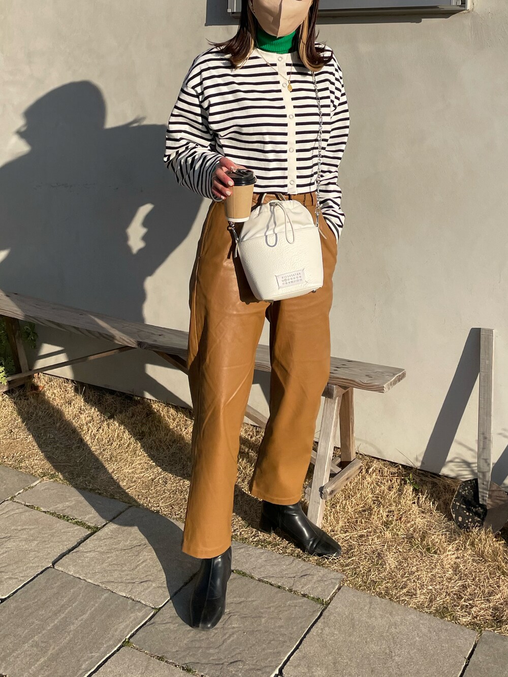 ブラック系のTシャツ/カットソー、ブラウン系のその他パンツ、ホワイト系のショルダーバッグを着用したレディースの冬コーディネートの4枚目の写真