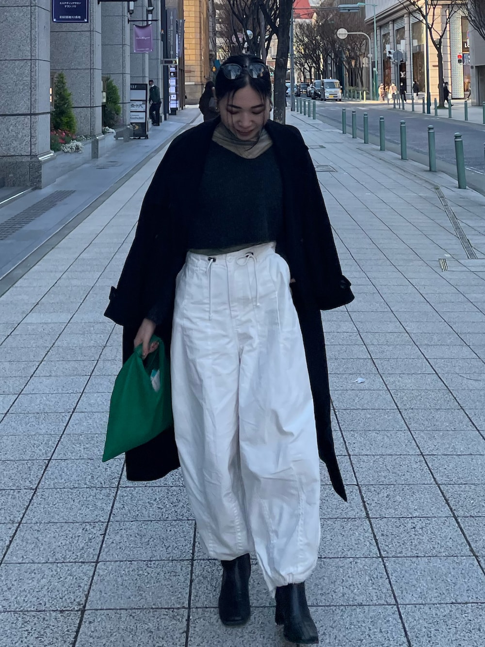 ブルー系のTシャツ/カットソー、グレー系のニット/セーター、グリーン系のショルダーバッグを着用したレディースの春コーディネートの4枚目の写真