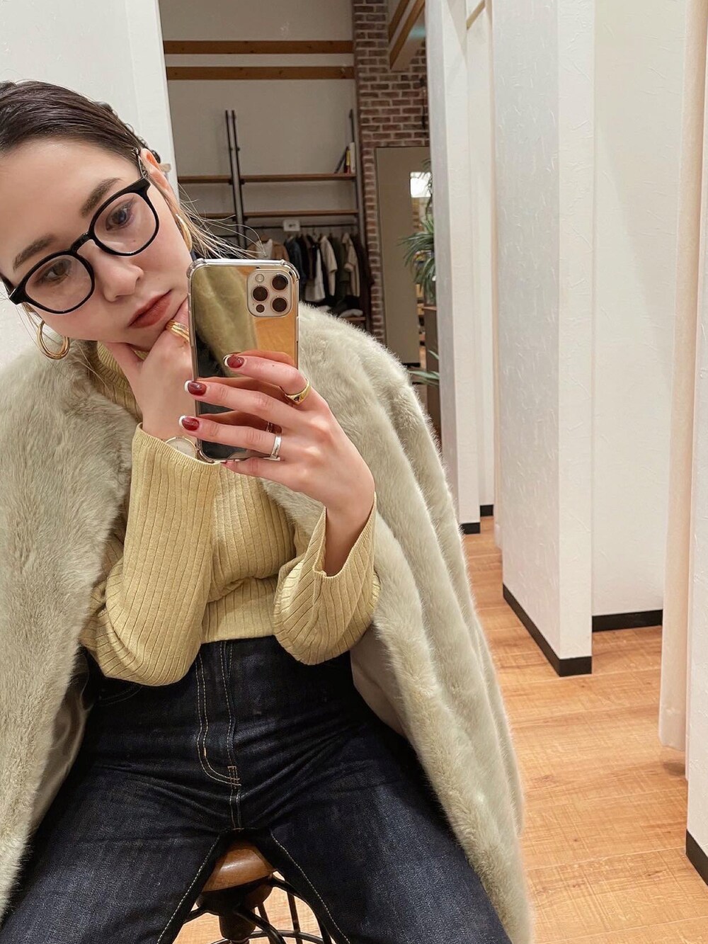 イエロー系のニット/セーター、ブルー系のデニムパンツ、グレー系のその他アウターを着用したレディースの冬コーディネートの2枚目の写真