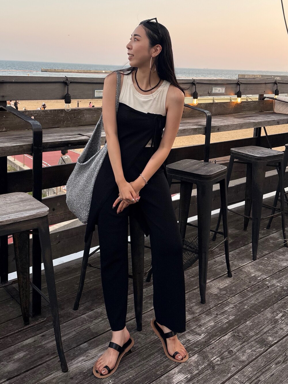 ブラック系のサンダル、シルバー系のトートバッグを着用したレディースの夏コーディネートの3枚目の写真