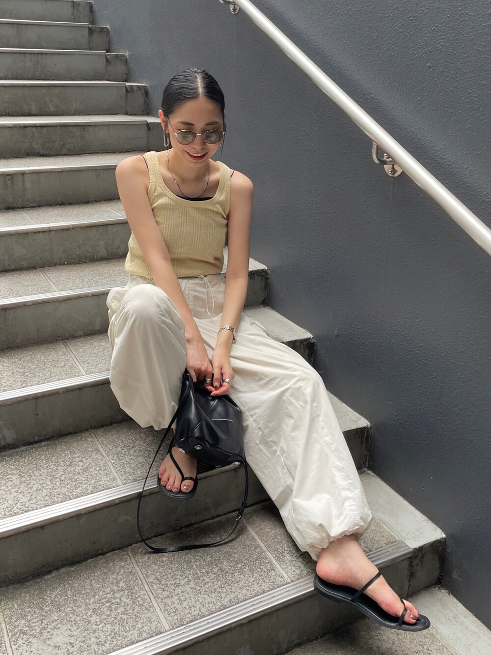 ホワイト系のカーゴパンツ、イエロー系のTシャツ/カットソー、ブラック系のショルダーバッグを着用したレディースの夏コーディネートの4枚目の写真