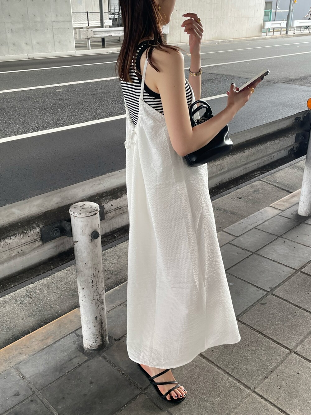 ホワイト系のタンクトップ、ホワイト系のワンピース、ブラック系のハンドバッグを着用したレディースの夏コーディネートの5枚目の写真