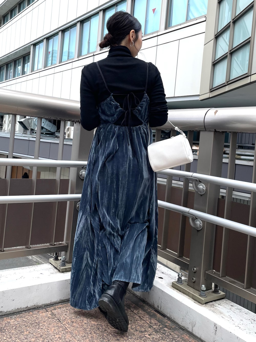 ホワイト系のハンドバッグ、ブルー系のワンピース、ブラック系のニット/セーターを着用したレディースの冬コーディネートの2枚目の写真