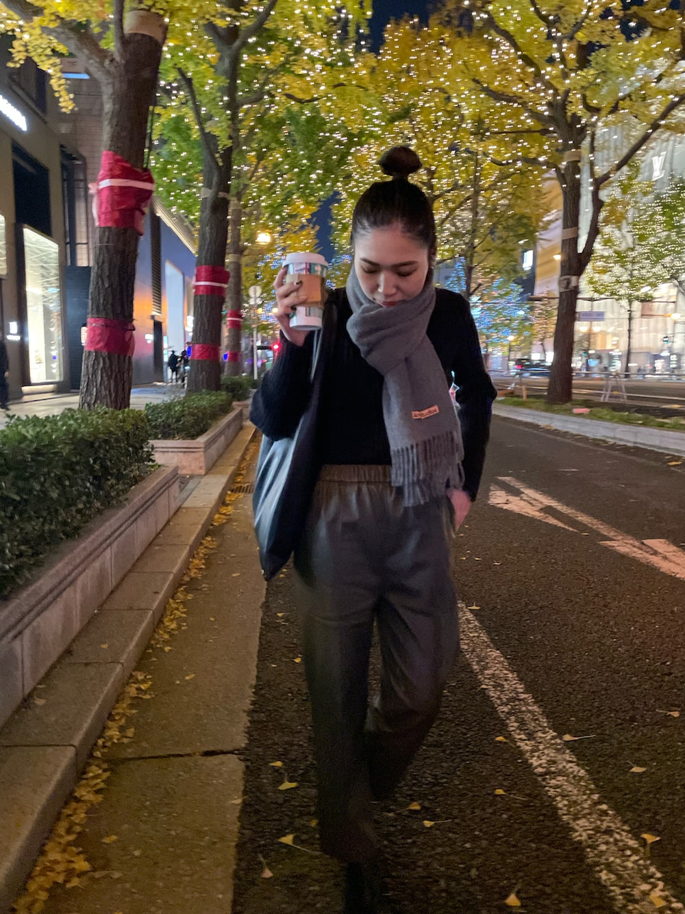 ブラック系のブーツ、ブラック系のニット/セーター、ブラック系のハンドバッグを着用したレディースの秋コーディネートの3枚目の写真