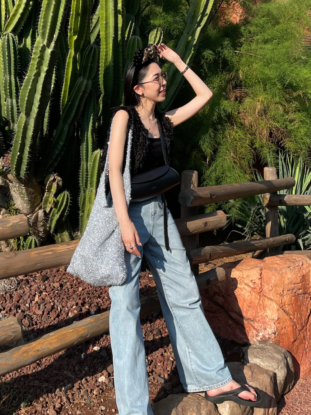 ブルー系のデニムパンツ、ブラック系のサンダル、ブラック系のキャミソールを着用したレディースの夏コーディネートの5枚目の写真