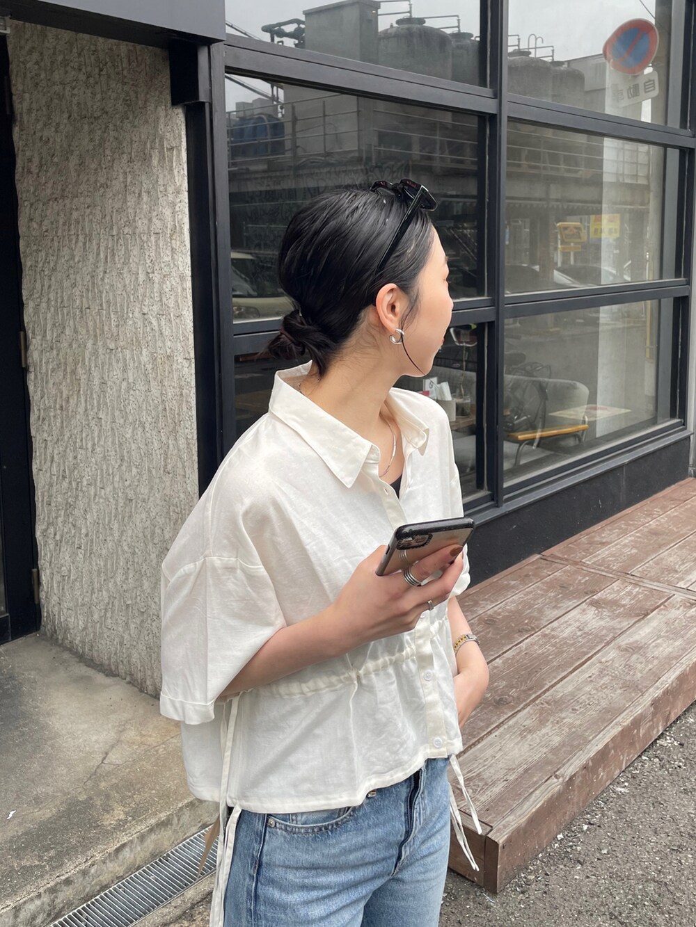 ブルー系のデニムパンツ、ゴールド系のサンダル、ホワイト系のシャツ/ブラウスを着用したレディースの春コーディネートの5枚目の写真