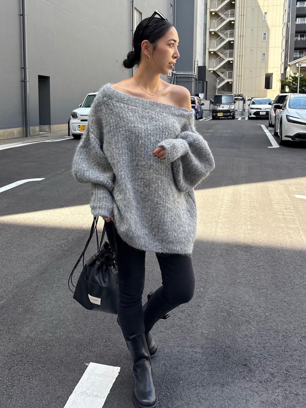 ブラック系のショルダーバッグ、ブラック系のブーツ、ブラック系のデニムパンツを着用したレディースの秋コーディネートの3枚目の写真