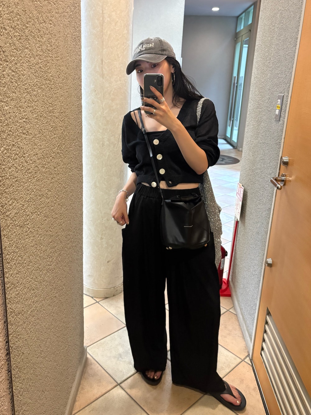 ブラック系のサンダル、ブラック系のショルダーバッグ、シルバー系のトートバッグを着用したレディースの夏コーディネートの3枚目の写真