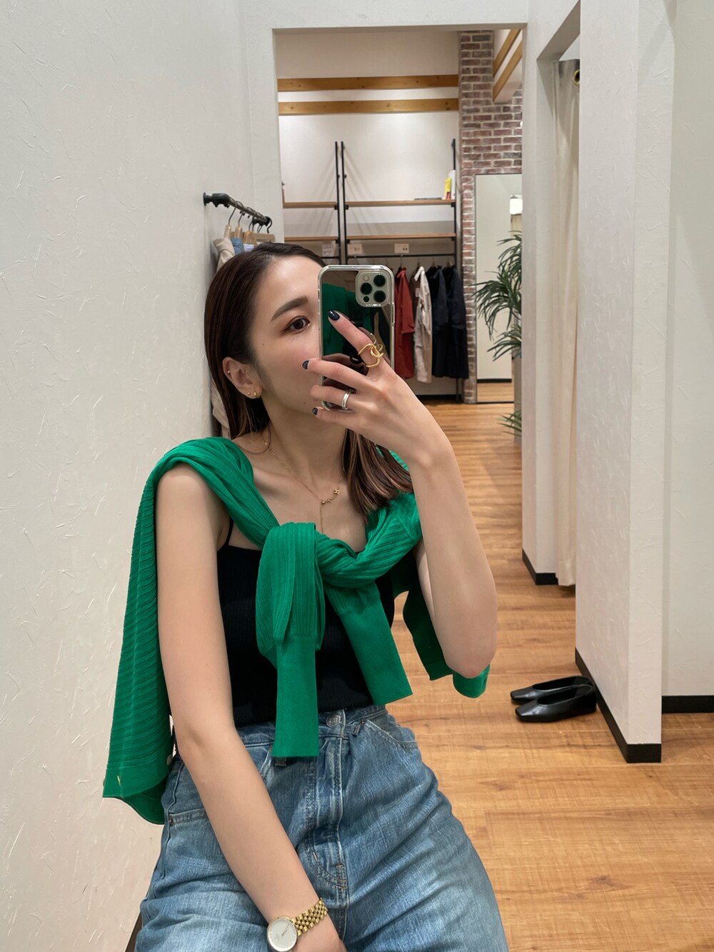 ブラック系のキャミソール、グリーン系のカーディガン/ボレロ、ブルー系のデニムパンツを着用したレディースの夏コーディネートの4枚目の写真