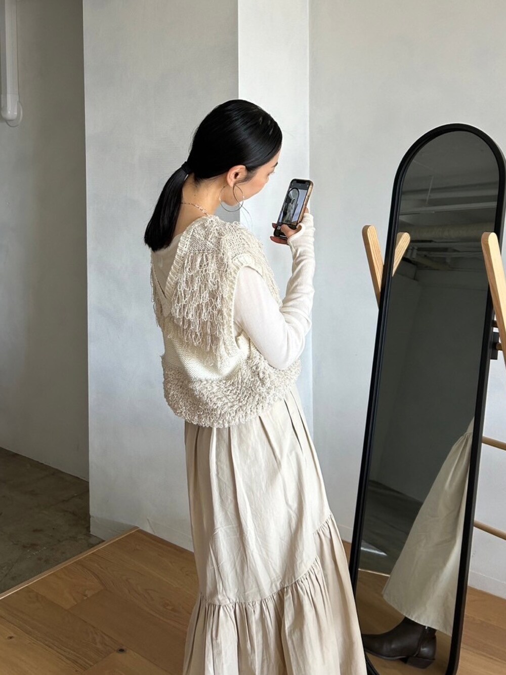 ホワイト系のスカート、ホワイト系のベスト、ホワイト系のTシャツ/カットソーを着用したレディースの春コーディネートの4枚目の写真