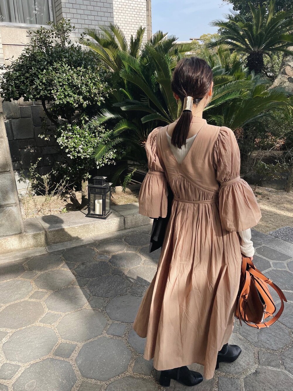 ベージュ系のワンピース、ブラウン系のハンドバッグを着用したレディースの春コーディネートの5枚目の写真