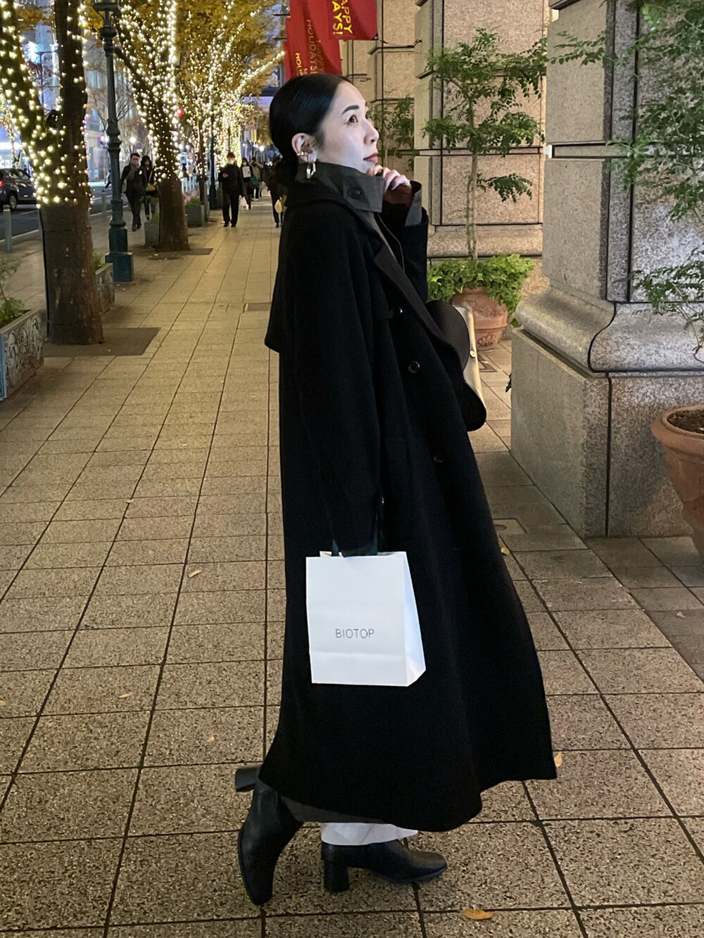 ブラック系のブーツ、ブラック系のチェスターコート、ブラック系のショルダーバッグを着用したレディースの冬コーディネートの5枚目の写真