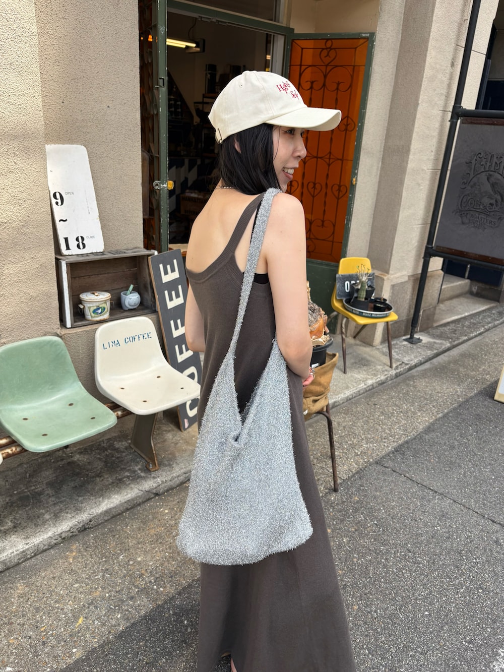 ブラック系のサンダル、シルバー系のトートバッグを着用したレディースの夏コーディネートの4枚目の写真