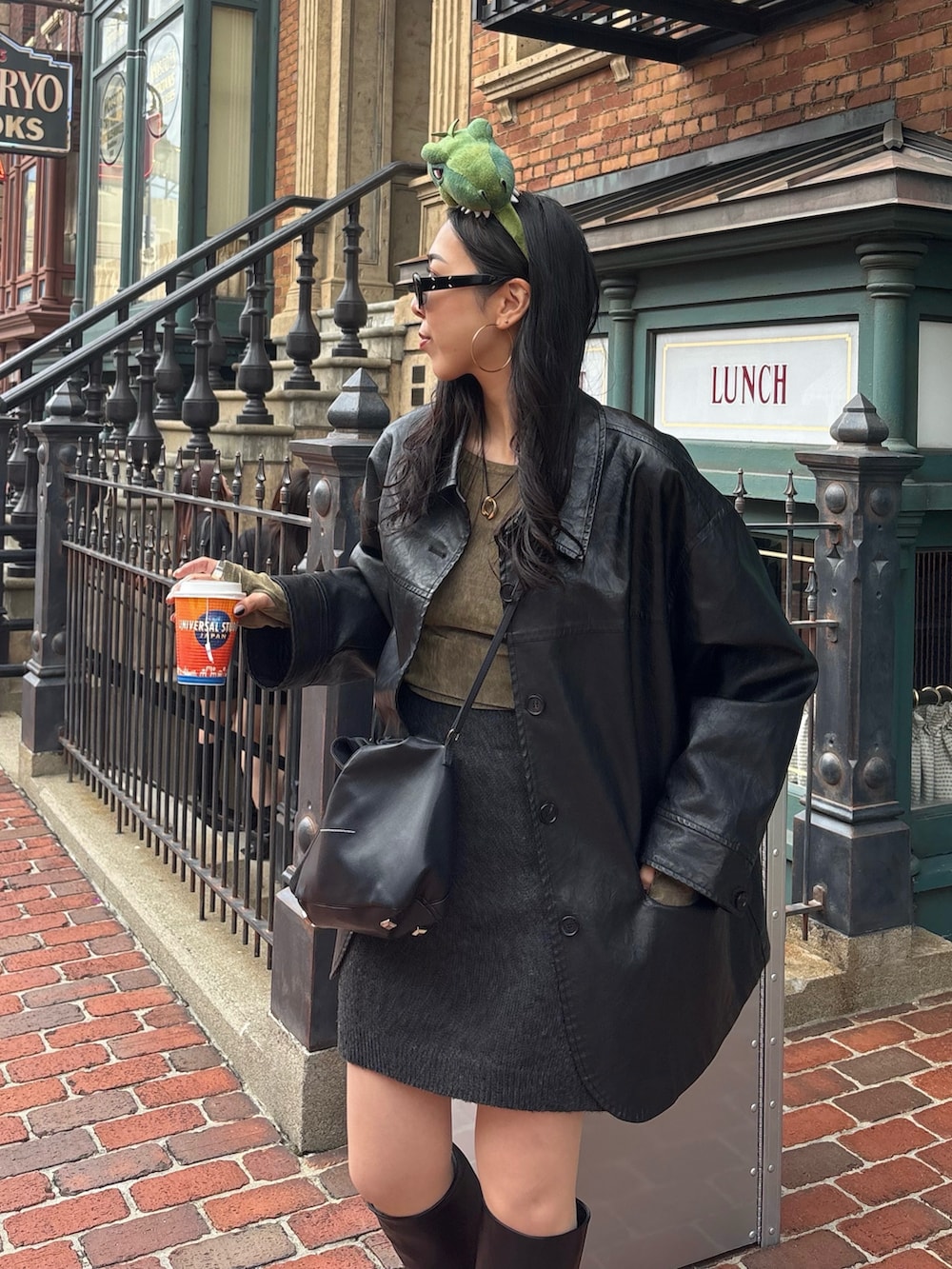 ブラック系のブーツ、ブラック系のショルダーバッグ、グリーン系のTシャツ/カットソーを着用したレディースの秋コーディネートの2枚目の写真