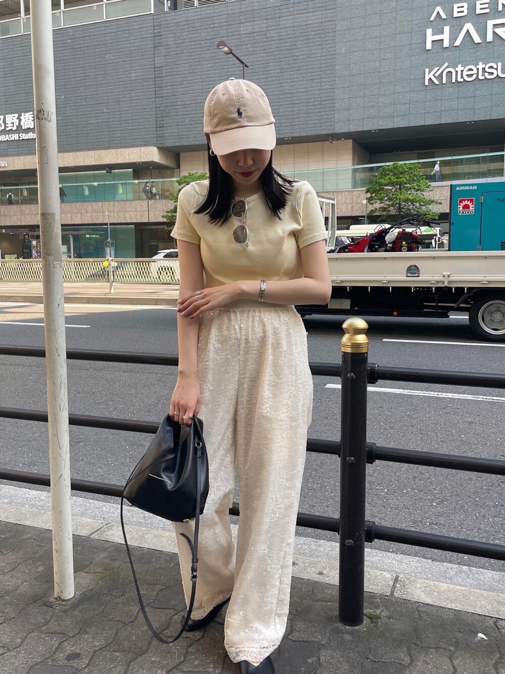 ホワイト系のその他パンツ、イエロー系のTシャツ/カットソー、ブラック系のショルダーバッグを着用したレディースの春コーディネートの5枚目の写真