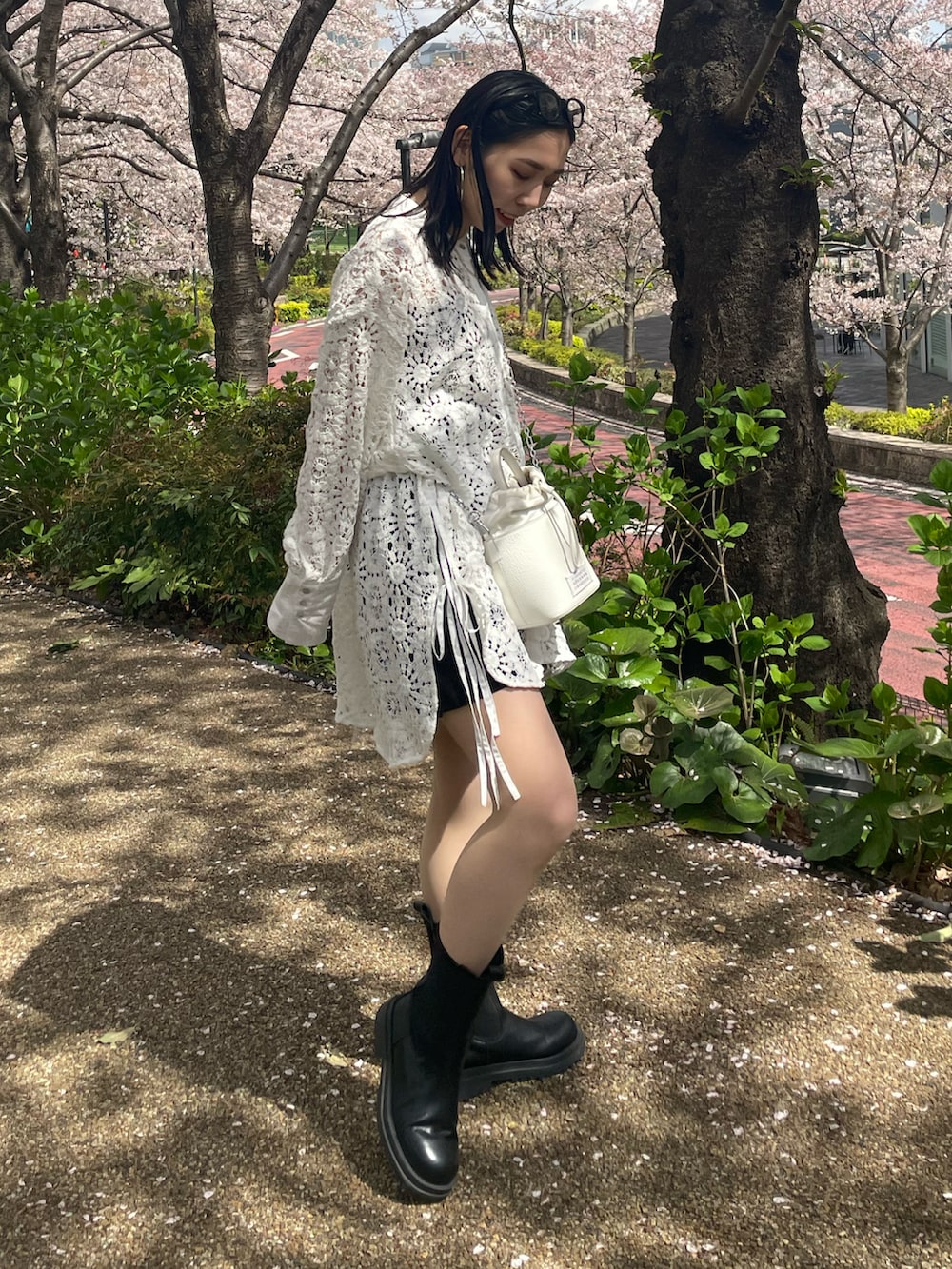 ブラック系のブーツ、ホワイト系のシャツ/ブラウス、ホワイト系のショルダーバッグを着用したレディースの春コーディネートの3枚目の写真