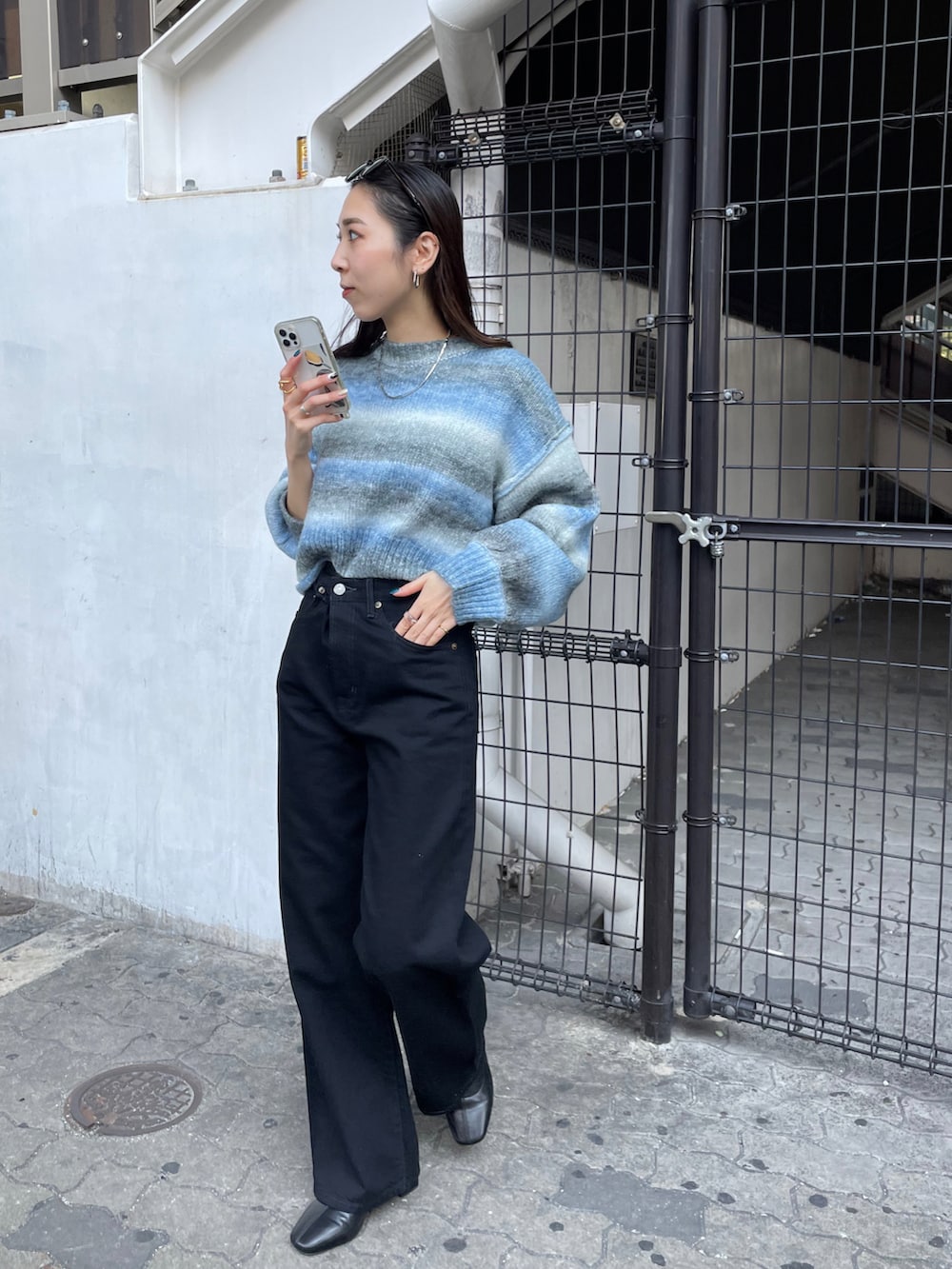 ブラック系のデニムパンツ、ブルー系のニット/セーターを着用したレディースの秋コーディネートの2枚目の写真