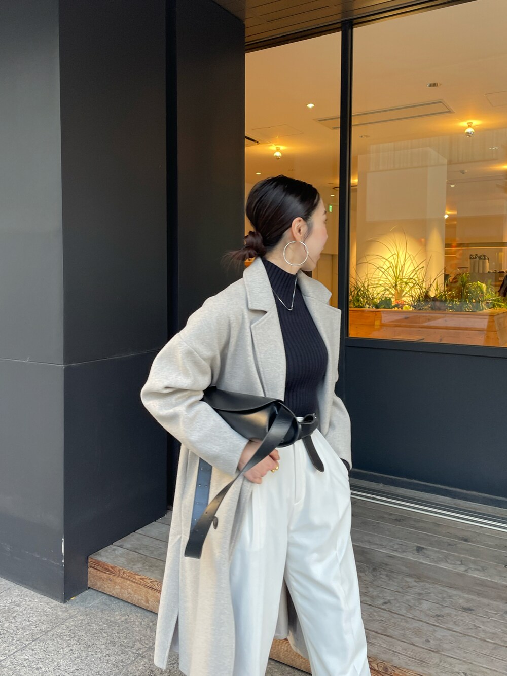 ブラック系のショルダーバッグ、ブラック系のブーツ、ブラック系のニット/セーターを着用したレディースの冬コーディネートの5枚目の写真