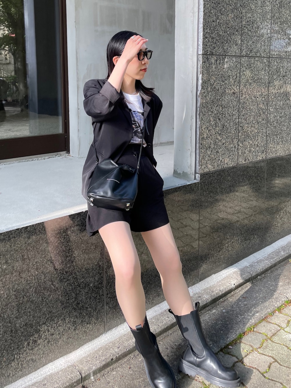 ブラック系のブーツ、ブラック系のショルダーバッグ、ホワイト系のTシャツ/カットソーを着用したレディースの春コーディネートの3枚目の写真