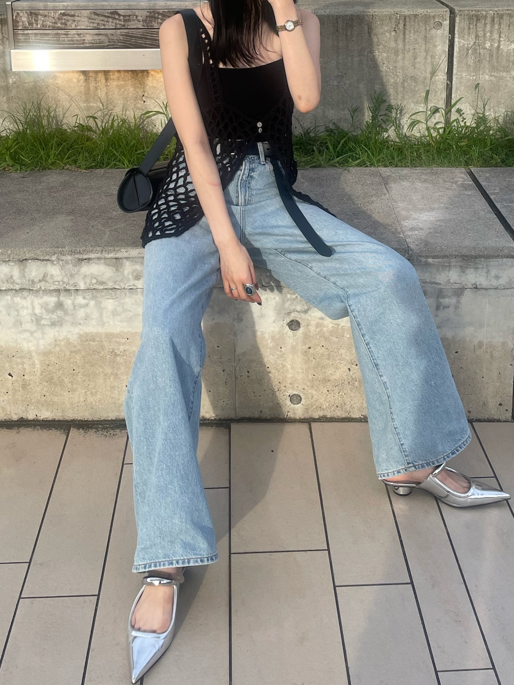 ブルー系のデニムパンツ、ブラック系のショルダーバッグ、ブラック系のキャミソールを着用したレディースの夏コーディネートの5枚目の写真