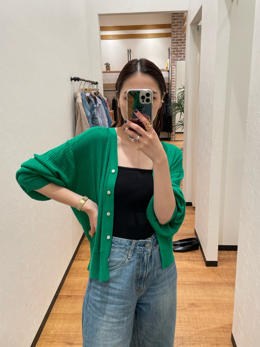 ブラック系のキャミソール、グリーン系のカーディガン/ボレロ、ブルー系のデニムパンツを着用したレディースの夏コーディネートの3枚目の写真