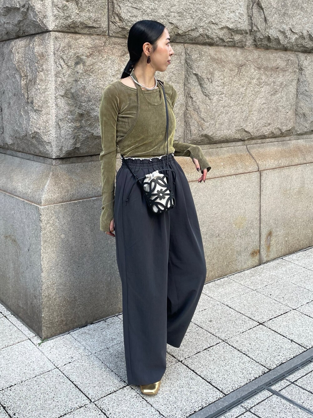 グレー系のその他パンツ、グリーン系のTシャツ/カットソー、ゴールド系のパンプスを着用したレディースの秋コーディネートの2枚目の写真