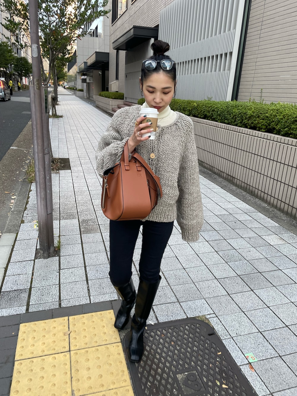 ブラウン系のバックパック/リュック、ブラック系のデニムパンツ、ブラック系のブーツを着用したレディースの秋コーディネートの3枚目の写真