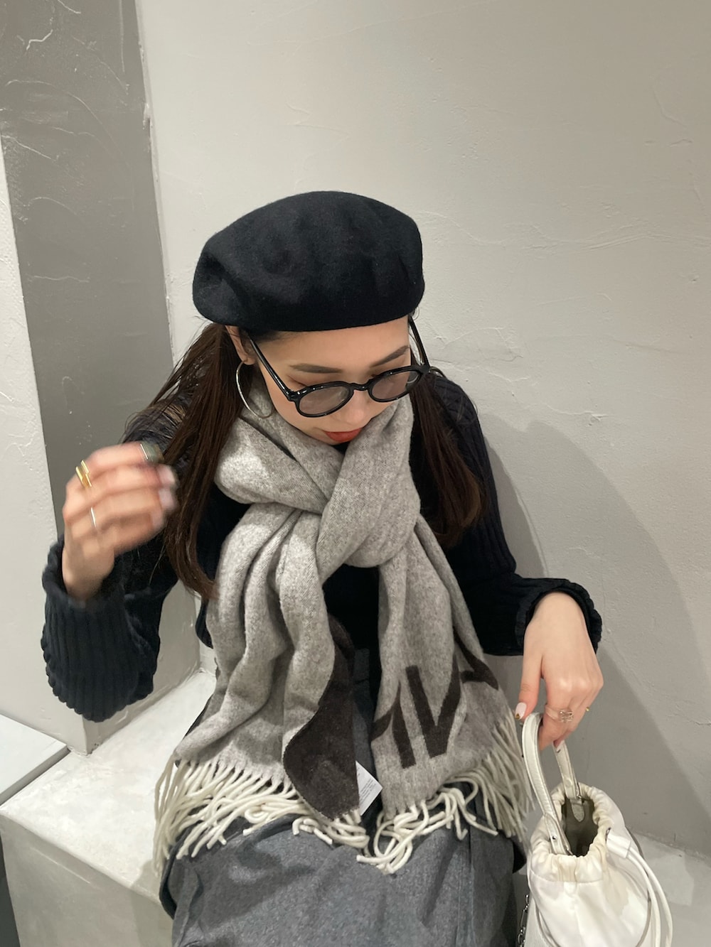 ホワイト系のショルダーバッグ、グレー系のカーゴパンツ、ブラック系のブーツを着用したレディースの冬コーディネートの3枚目の写真