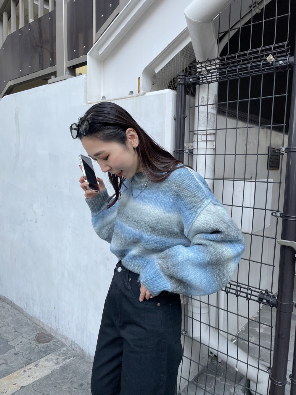 ブラック系のデニムパンツ、ブルー系のニット/セーターを着用したレディースの秋コーディネートの4枚目の写真