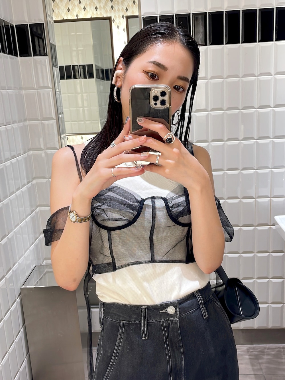 ゴールド系のパンプス、ブラック系のデニムパンツ、ブラック系のショルダーバッグを着用したレディースの秋コーディネートの4枚目の写真