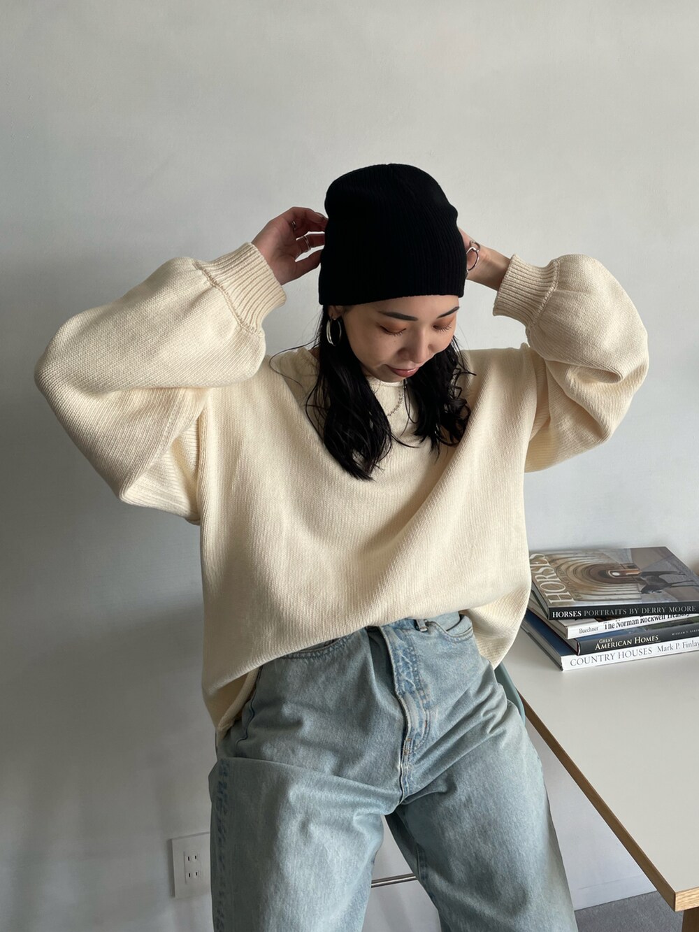 ホワイト系のニット/セーター、ブルー系のデニムパンツ、ブラック系のニットキャップ/ビーニーを着用したレディースの秋コーディネートの4枚目の写真