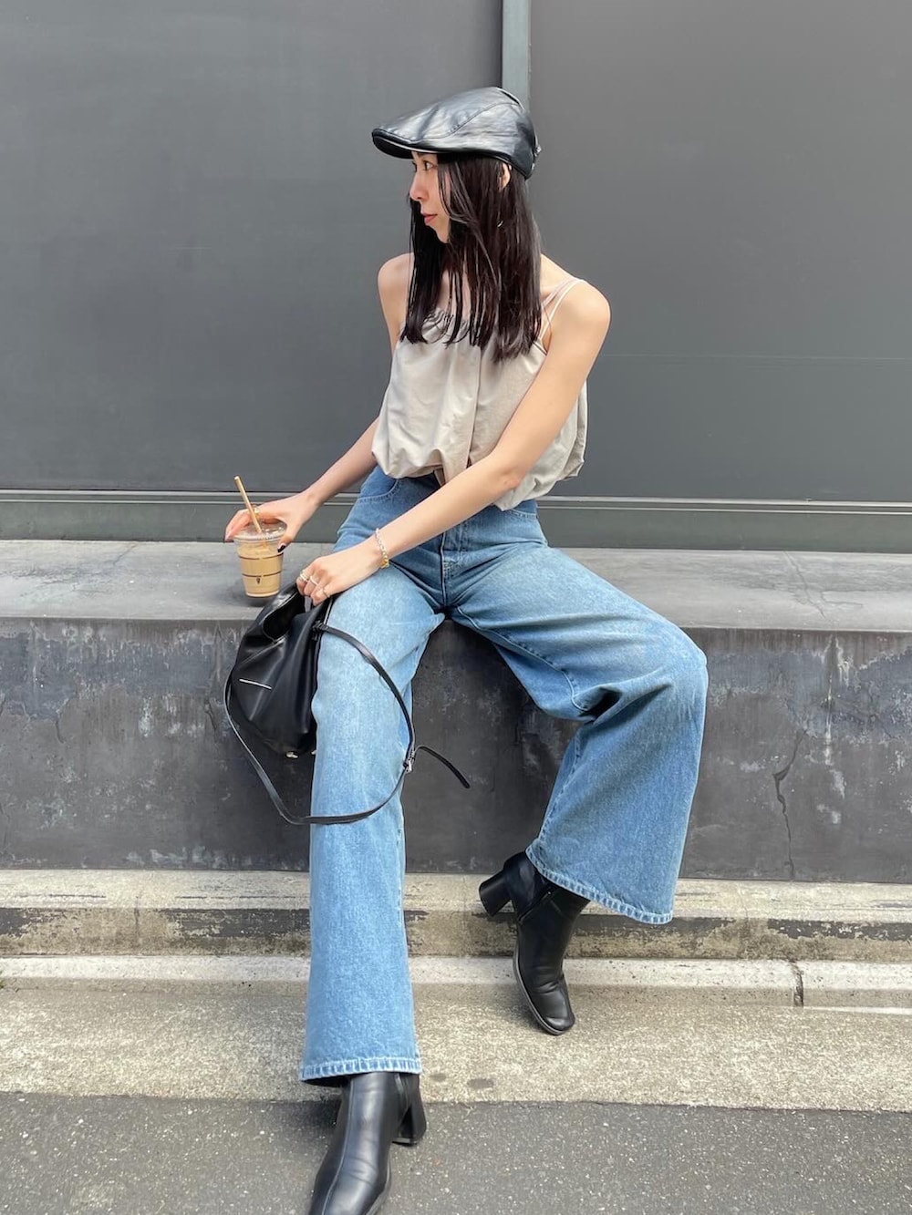 ブラック系のショルダーバッグ、ブラック系のブーツ、ブラック系のハンチング/ベレー帽を着用したレディースの春コーディネートの2枚目の写真