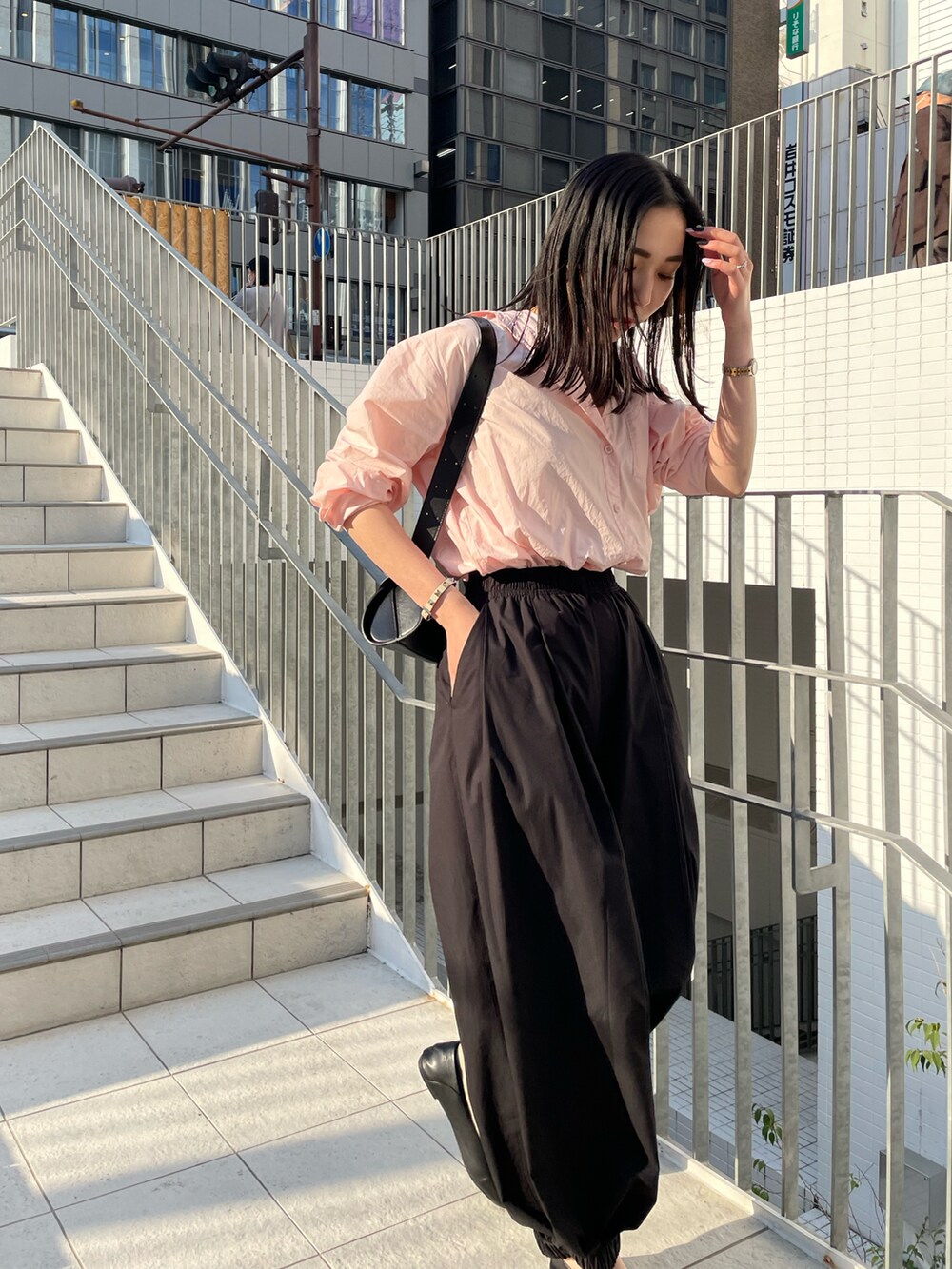 ピンク系のシャツ/ブラウス、ブラック系のその他パンツ、ブラック系のショルダーバッグを着用したレディースの春コーディネートの3枚目の写真