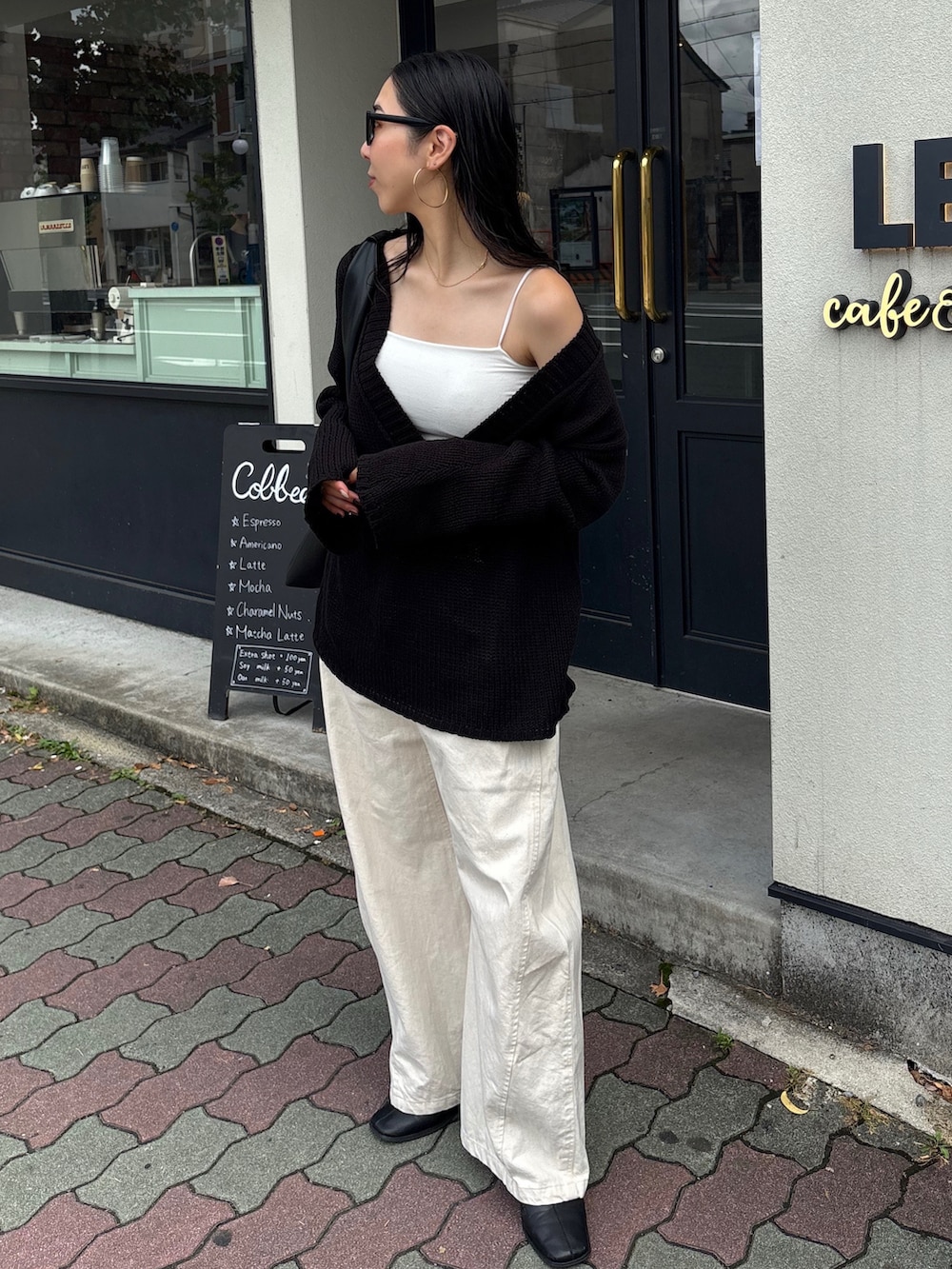 ブラック系のハンドバッグ、ブラック系のブーツを着用したレディースの夏コーディネートの2枚目の写真