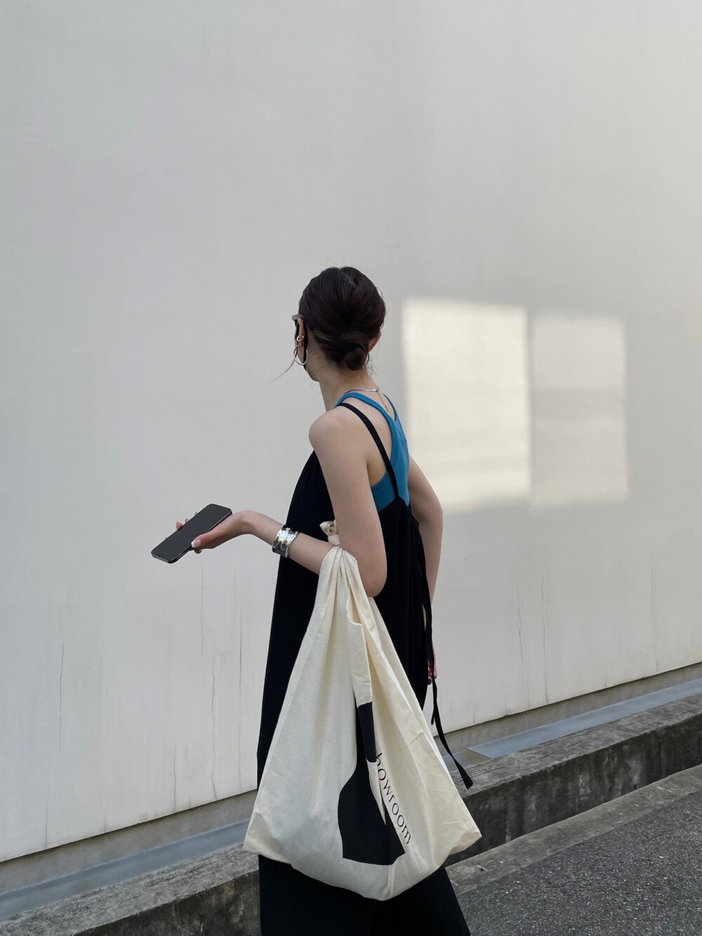 ブラック系のオールインワン・サロペット、ブルー系のタンクトップ、ブラック系のサンダルを着用したレディースの春コーディネートの4枚目の写真