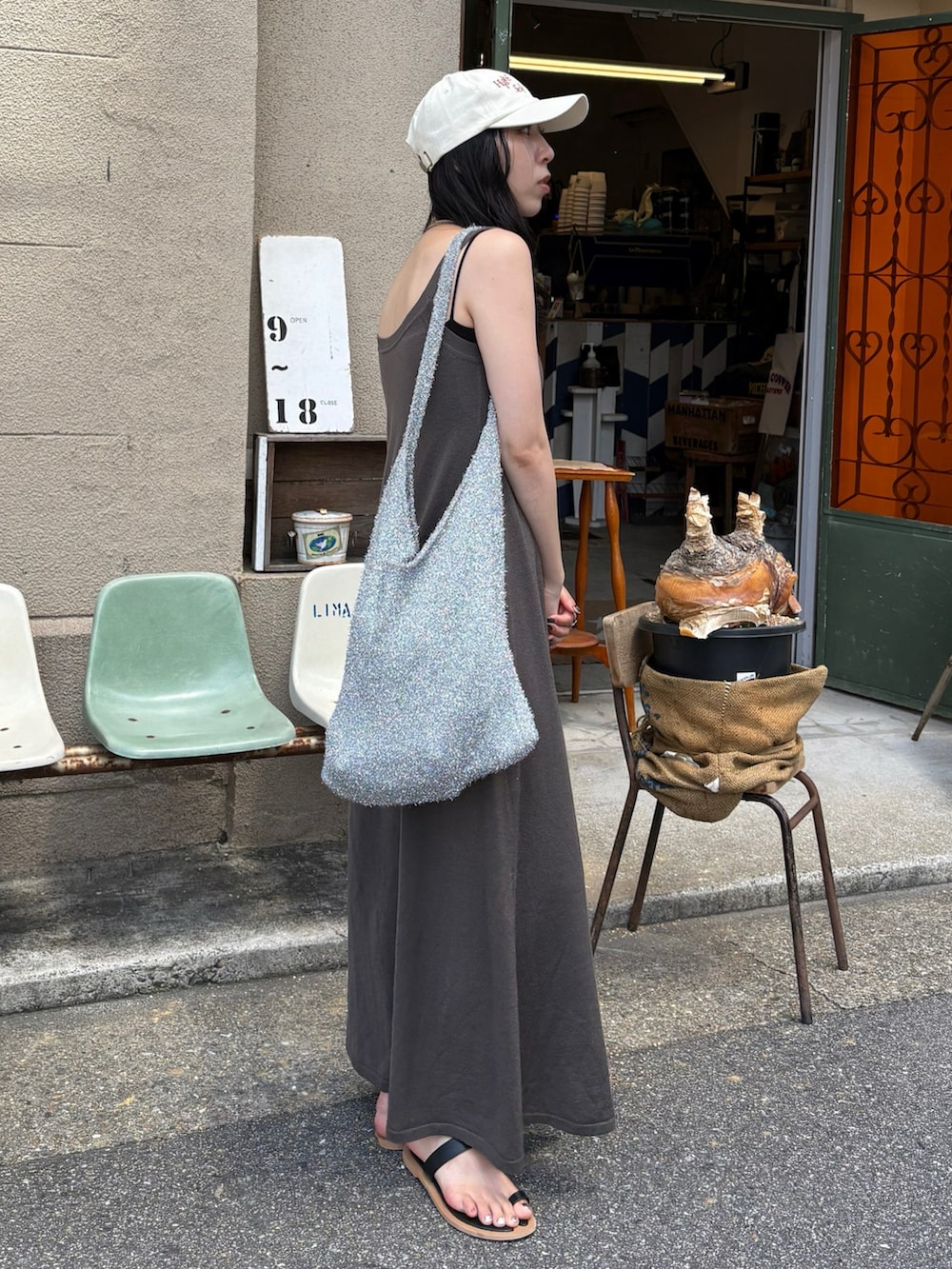 ブラック系のサンダル、シルバー系のトートバッグを着用したレディースの夏コーディネートの2枚目の写真