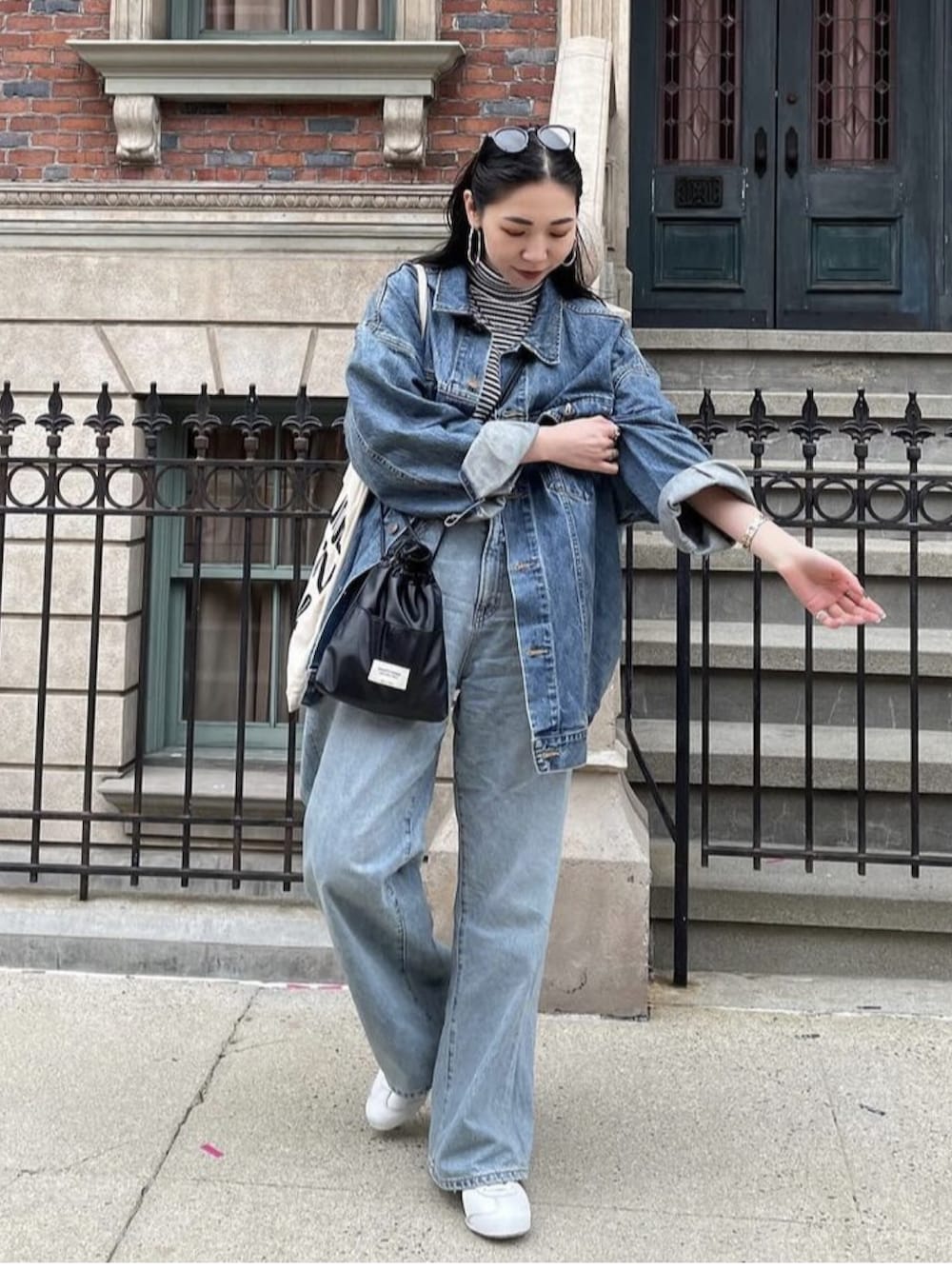 ブラック系のショルダーバッグ、ホワイト系のトートバッグ、ブルー系のデニムジャケットを着用したレディースの冬コーディネートの3枚目の写真