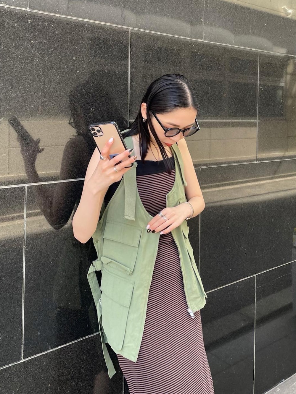 ブラック系のパンプス、ブラウン系のワンピース、グリーン系のベストを着用したレディースの春コーディネートの3枚目の写真