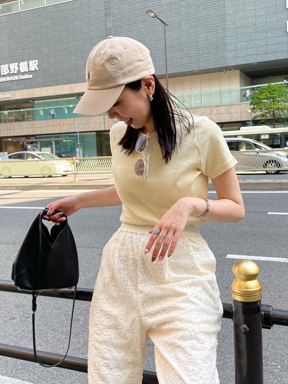 ホワイト系のその他パンツ、イエロー系のTシャツ/カットソー、ブラック系のショルダーバッグを着用したレディースの春コーディネートの3枚目の写真