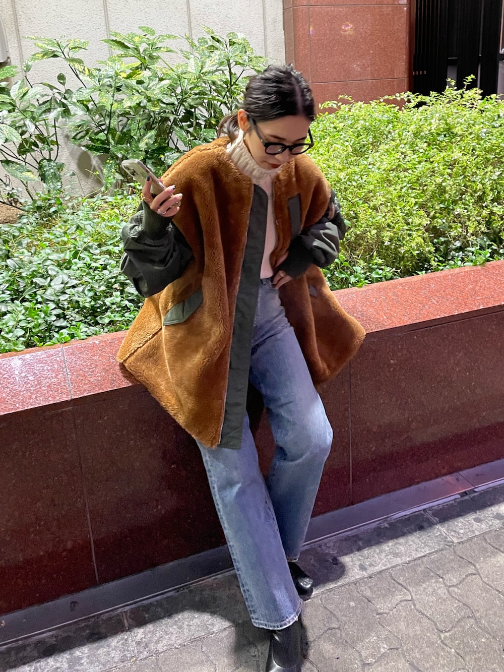 グリーン系のブルゾン、ブルー系のデニムパンツ、ホワイト系のニット/セーターを着用したレディースの秋コーディネートの3枚目の写真