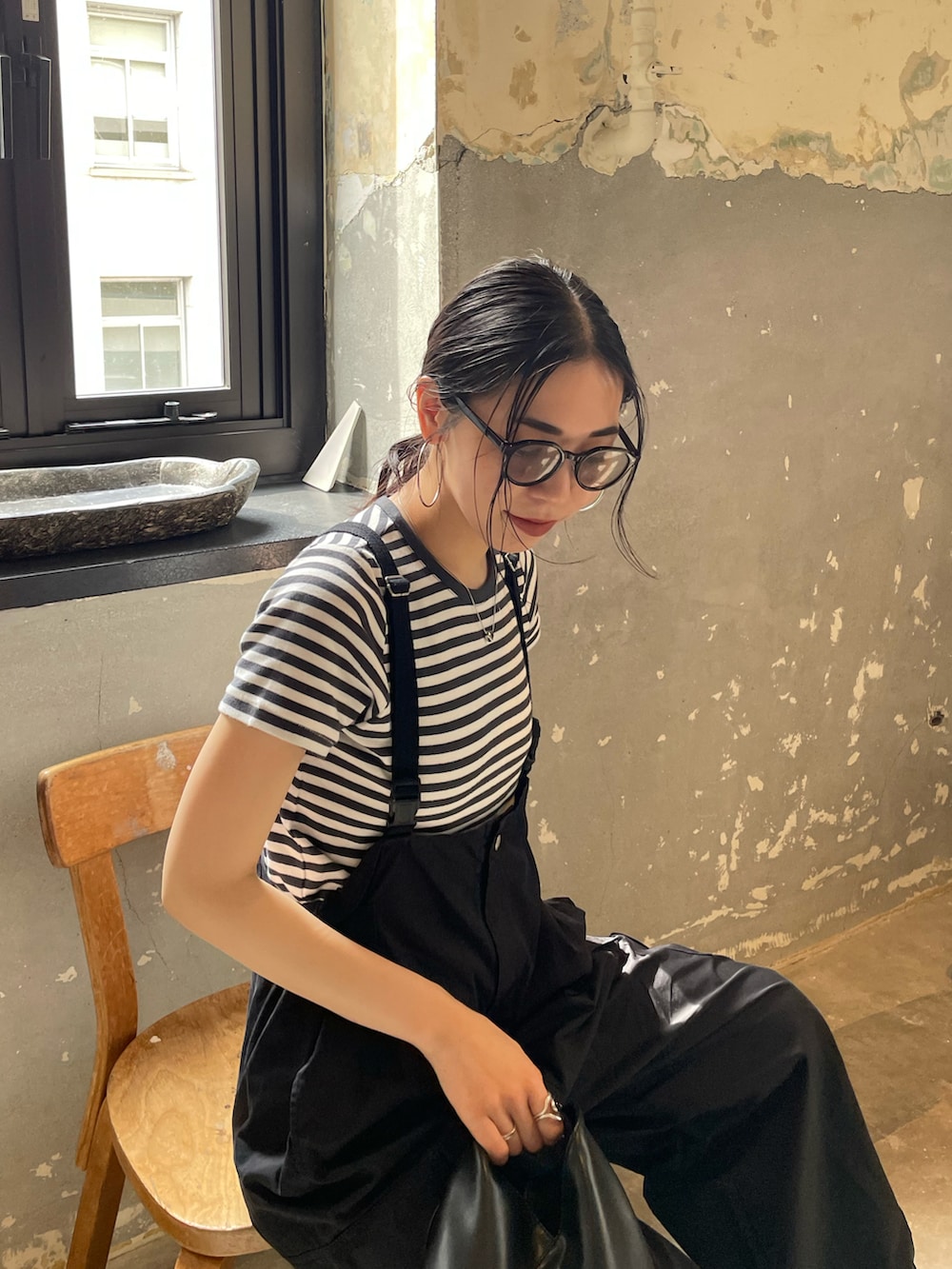 ブラック系のサロペット/オーバーオール、グレー系のTシャツ/カットソー、ホワイト系のスニーカーを着用したレディースの春コーディネートの4枚目の写真