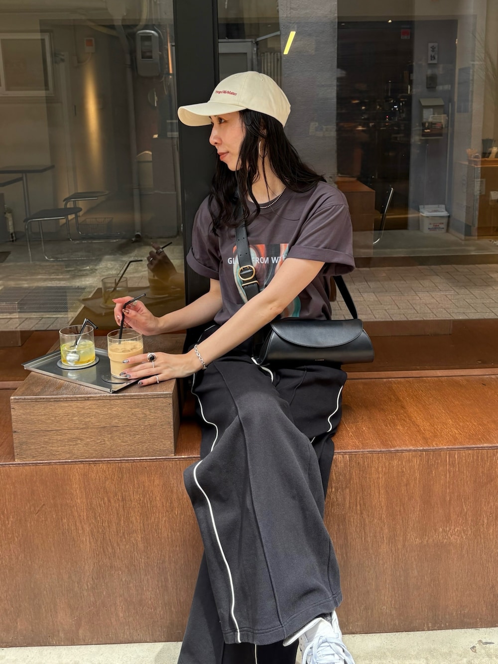 ホワイト系のスニーカー、ブラック系のショルダーバッグ、ブラック系のその他パンツを着用したレディースの夏コーディネートの5枚目の写真