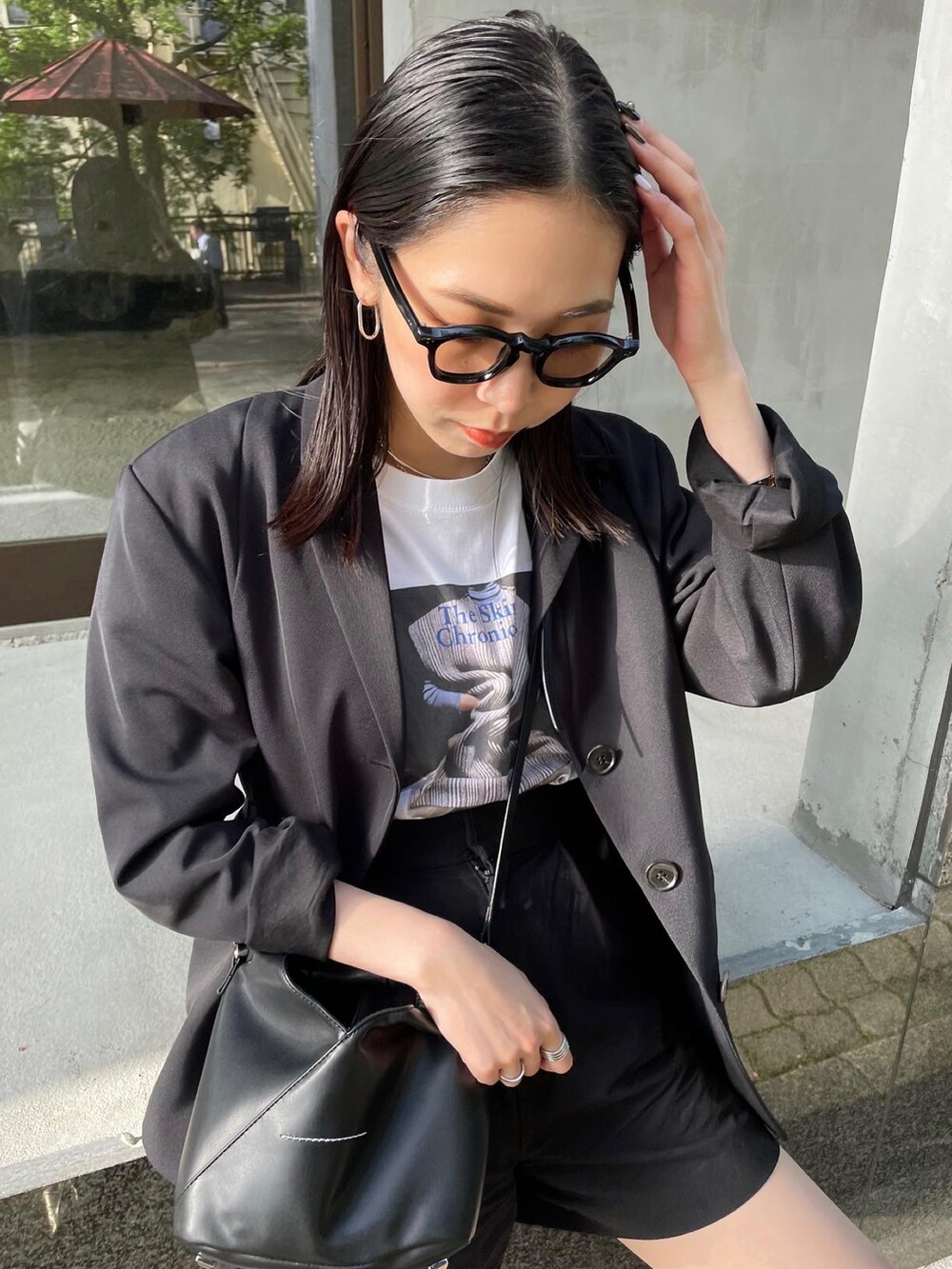 ブラック系のブーツ、ブラック系のショルダーバッグ、ホワイト系のTシャツ/カットソーを着用したレディースの春コーディネートの4枚目の写真