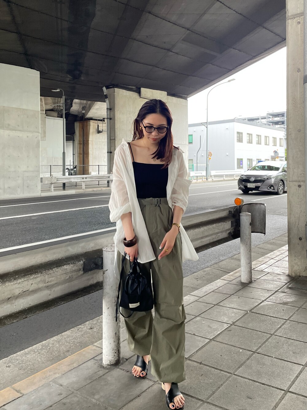 ブラック系のキャミソール、ホワイト系のシャツ/ブラウス、ブラック系のショルダーバッグを着用したレディースの春コーディネートの3枚目の写真