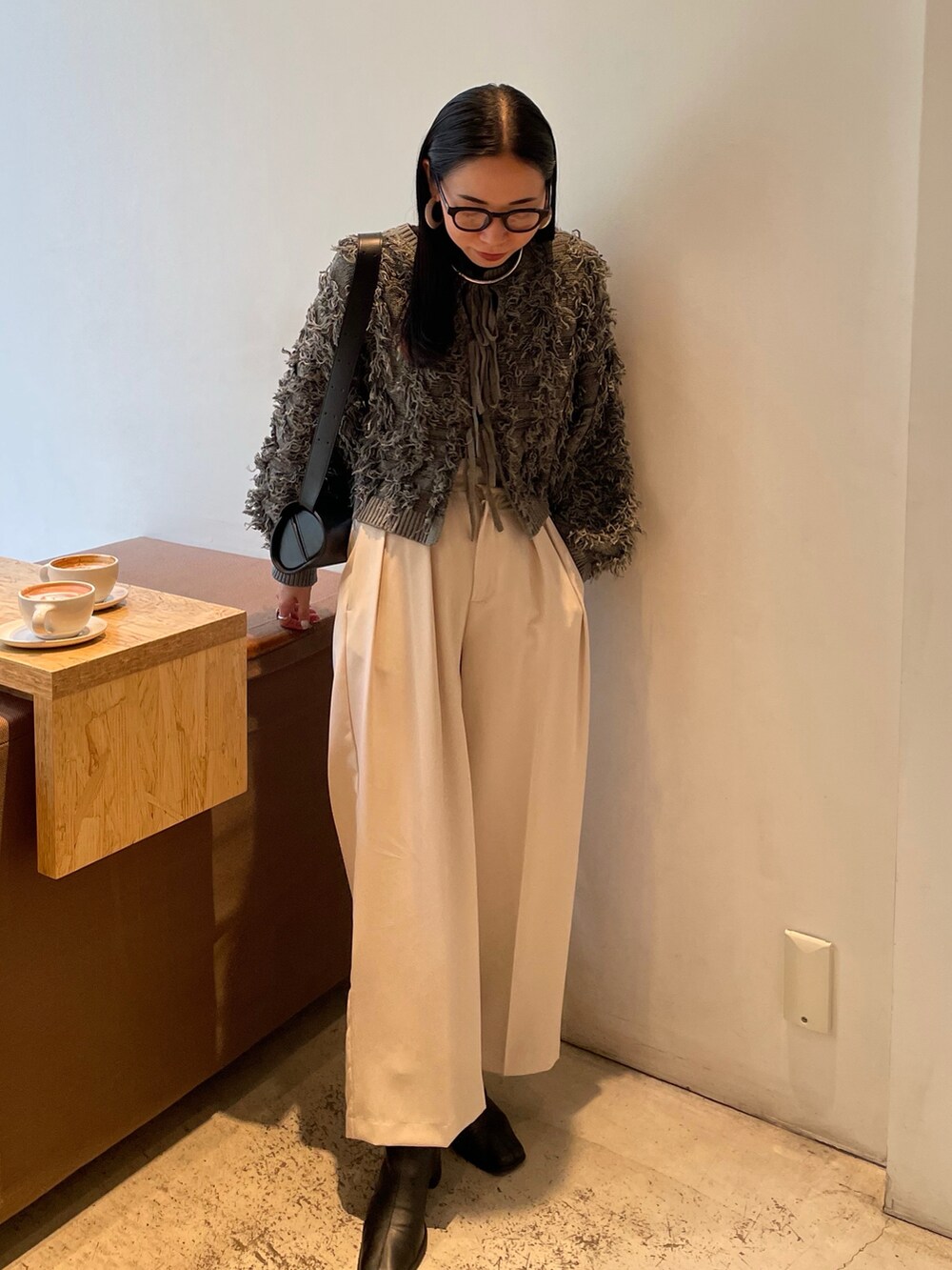 ホワイト系のその他パンツ、ブラック系のブーツ、グレー系のニット/セーターを着用したレディースの秋コーディネートの3枚目の写真
