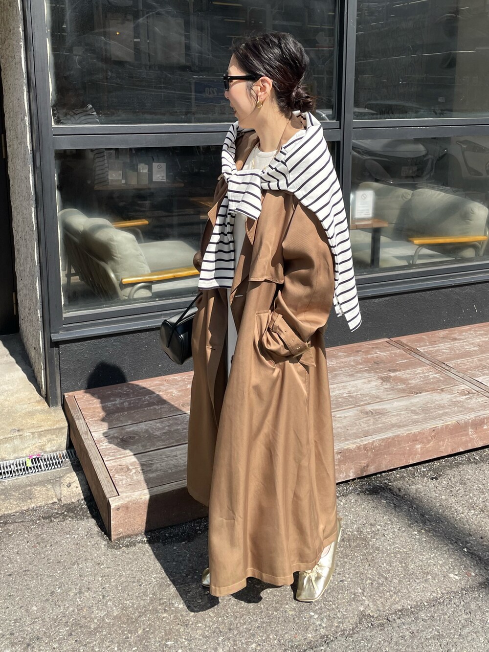 ゴールド系のパンプス、イエロー系のトレンチコート、ホワイト系のワンピースを着用したレディースの冬コーディネートの4枚目の写真