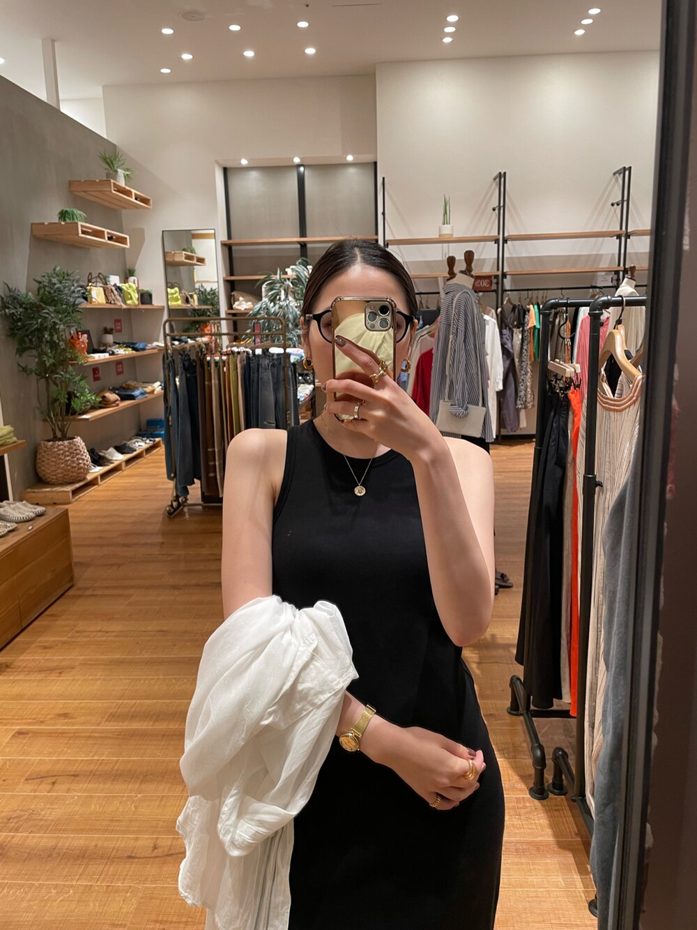 ブラック系のワンピース、ホワイト系のシャツ/ブラウス、ブラック系のスニーカーを着用したレディースの夏コーディネートの3枚目の写真