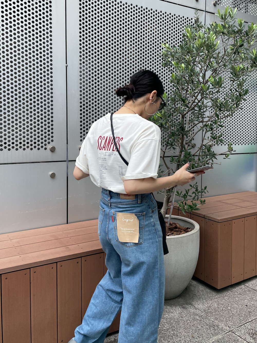 ブルー系のデニムパンツ、ホワイト系のTシャツ/カットソー、グレー系のサンダルを着用したレディースの夏コーディネートの4枚目の写真