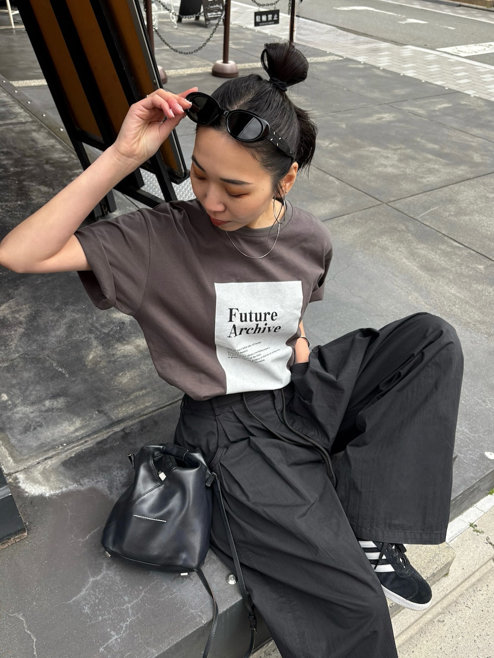 ブラック系のスニーカーを着用したレディースの春コーディネートの4枚目の写真