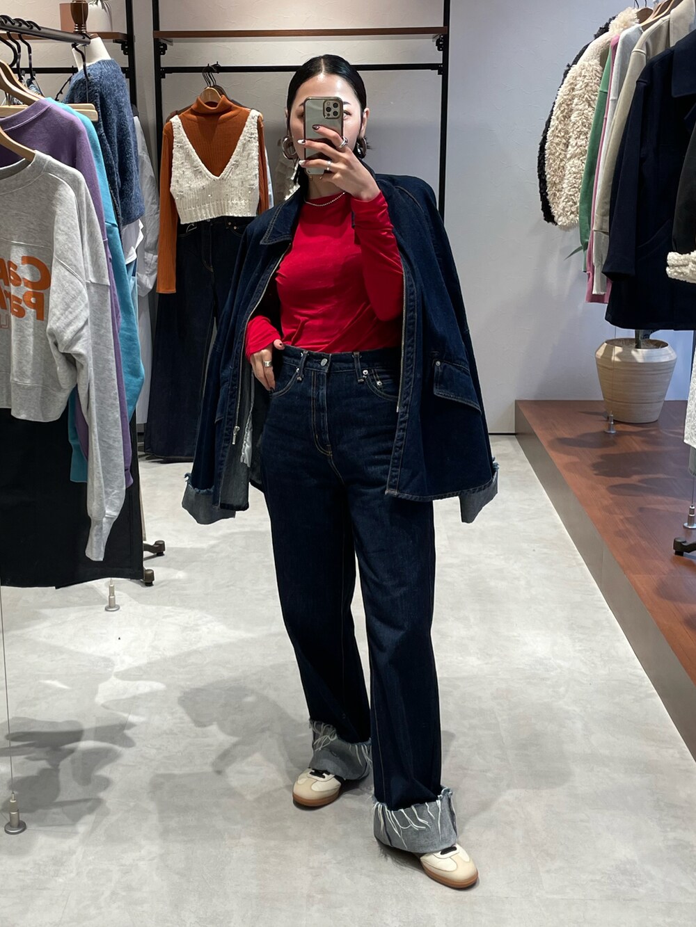 ブルー系のデニムパンツ、ベージュ系のスニーカー、ブルー系のデニムジャケットを着用したレディースの秋コーディネートの2枚目の写真